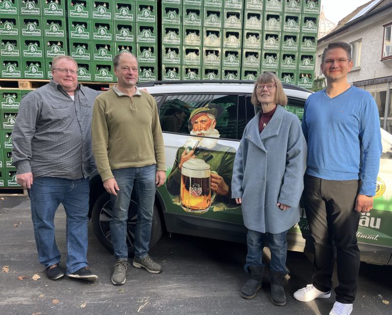 Gampertbräu-Auto Annette und Christian Höfner stehen zusammen mit anderen vor einem Gampertbräu-Auto